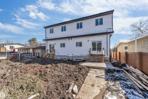 The property features a two-story exterior with white siding and black trim, complemented by several windows - 10962 157 Street, Edmonton, AB - Outdoor