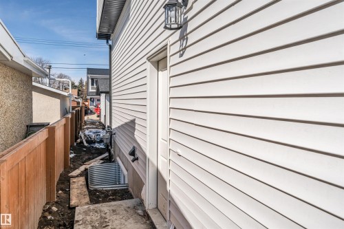 The property features white horizontal siding and an exterior light fixture - 10962 157 Street, Edmonton, AB - Outdoor With Exterior