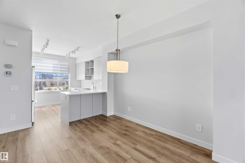 Living space featuring light wood-style flooring, white walls, and a modern drum pendant light fixture - 49 100 Jensen Lakes Boulevard, St. Albert, AB - Indoor Photo Showing Kitchen