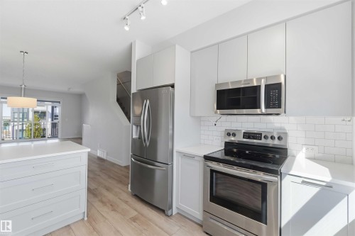 Well-appointed kitchen featuring light-toned cabinetry, stainless steel appliances, and subway tile backsplash - 49 100 Jensen Lakes Boulevard, St. Albert, AB - Indoor Photo Showing Kitchen With Upgraded Kitchen