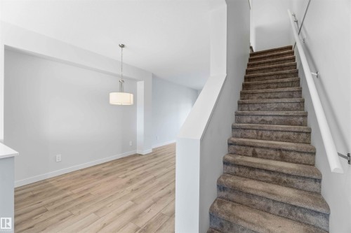 The property features a staircase with carpeted treads and a handrail - 49 100 Jensen Lakes Boulevard, St. Albert, AB - Indoor Photo Showing Other Room