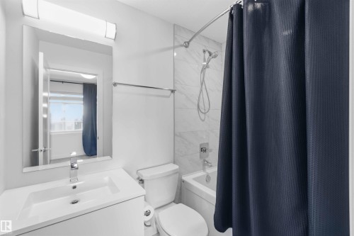 Well-appointed bathroom featuring a vanity with an integrated sink, a toilet, and a bathtub with a shower - 49 100 Jensen Lakes Boulevard, St. Albert, AB - Indoor Photo Showing Bathroom