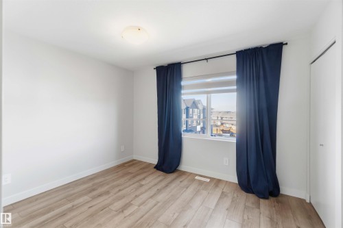 This room features light wood-style flooring, white walls, and a window with a view of the surrounding properties - 49 100 Jensen Lakes Boulevard, St. Albert, AB - Indoor Photo Showing Other Room