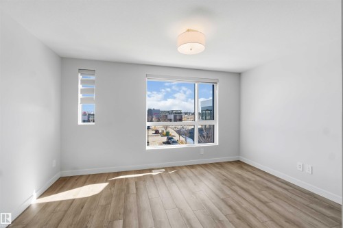 This bright room features light-toned flooring, white walls, and a contemporary ceiling light fixture - 49 100 Jensen Lakes Boulevard, St. Albert, AB - Indoor Photo Showing Other Room