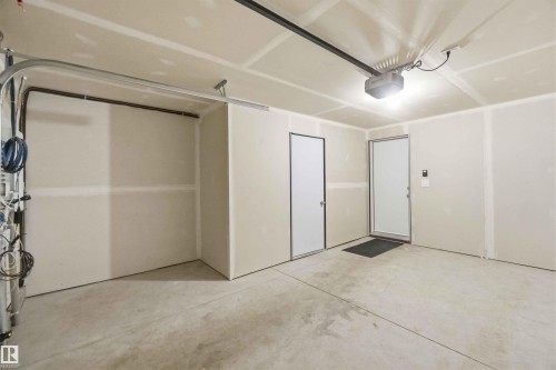 The property includes an attached garage with a concrete floor, a garage door opener, and two entry doors - 49 100 Jensen Lakes Boulevard, St. Albert, AB - Indoor