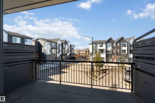 The property features a private balcony with a dark gray slatted privacy fence and a black metal railing - 49 100 Jensen Lakes Boulevard, St. Albert, AB - Outdoor