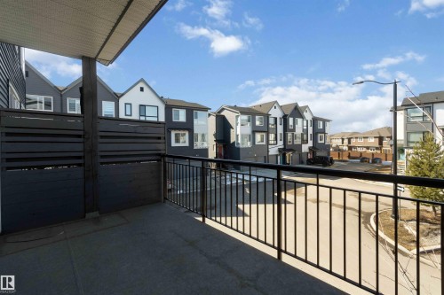 The property features a private balcony with a dark slatted privacy screen and black metal railings - 49 100 Jensen Lakes Boulevard, St. Albert, AB - Outdoor