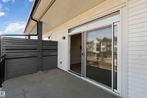 The property features a private balcony with a concrete floor, a black metal railing, and privacy screens - 49 100 Jensen Lakes Boulevard, St. Albert, AB - Outdoor With Exterior