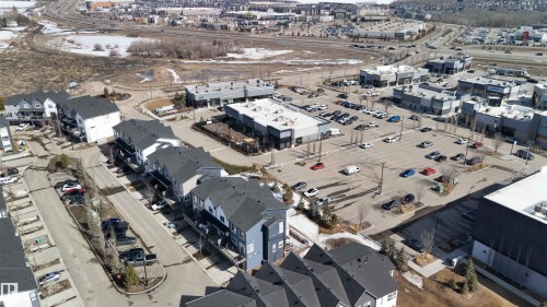 The property is situated in a community featuring a mix of residential buildings and commercial establishments with ample parking - 49 100 Jensen Lakes Boulevard, St. Albert, AB - Outdoor With View