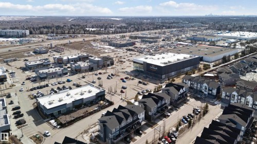 Aerial view showcasing the neighborhood, featuring residential properties with dark roofs and light-colored facades, alongside commercial buildings with ample parking - 49 100 Jensen Lakes Boulevard, St. Albert, AB - Outdoor With View