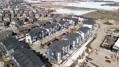 Aerial view of the community, showcasing residential properties with dark-colored roofs and a structured street layout - 49 100 Jensen Lakes Boulevard, St. Albert, AB - Outdoor With View