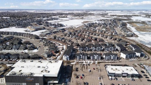 Expansive aerial view showcasing a well-developed residential area with numerous properties, winding roads, and commercial establishments - 49 100 Jensen Lakes Boulevard, St. Albert, AB - Outdoor With View