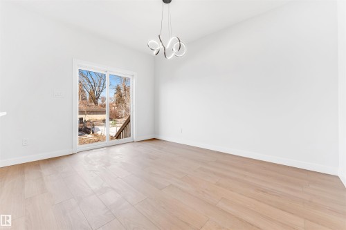 Living area with light-toned flooring, white walls, and a modern ceiling light fixture - 10964 157 Street, Edmonton, AB - Indoor Photo Showing Other Room