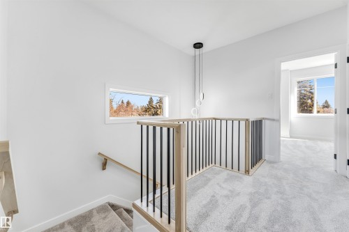 Upper level landing featuring light-toned carpeting and a modern light fixture - 10964 157 Street, Edmonton, AB - Indoor Photo Showing Other Room