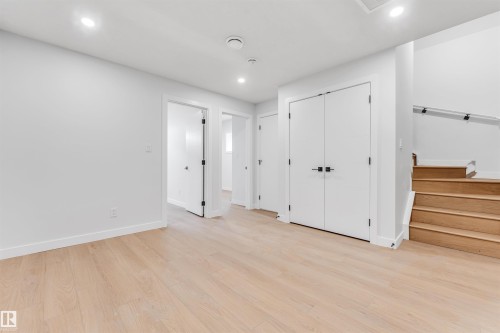 This interior space features light-toned hardwood flooring, white walls, and recessed lighting - 10964 157 Street, Edmonton, AB - Indoor Photo Showing Other Room