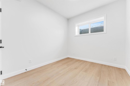 This room features light-colored flooring, white walls, and a window with a white frame - 10964 157 Street, Edmonton, AB - Indoor Photo Showing Other Room
