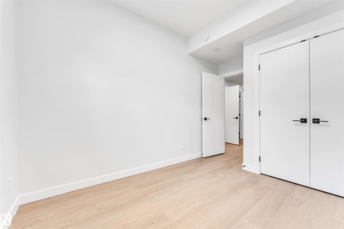 This room features light hardwood flooring and white walls, creating a bright and airy atmosphere - 10964 157 Street, Edmonton, AB - Indoor Photo Showing Other Room