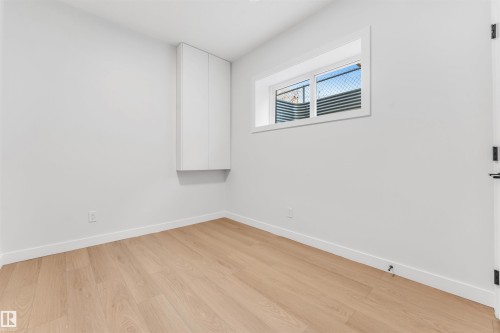 This room features light-toned hardwood flooring, white walls, and a white baseboard trim - 10964 157 Street, Edmonton, AB - Indoor Photo Showing Other Room