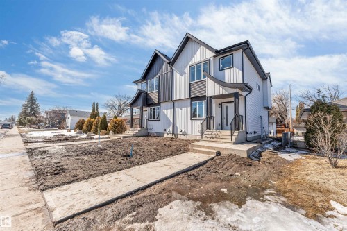 The property features a modern exterior with a white and dark grey facade, a front entrance with steps, and a sidewalk leading to the front door - 10964 157 Street, Edmonton, AB - Outdoor