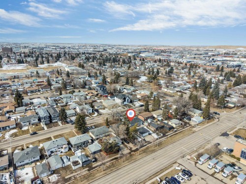 Aerial view of the property and surrounding neighborhood, featuring residential homes, mature trees, and nearby commercial buildings - 10964 157 Street, Edmonton, AB - Outdoor With View