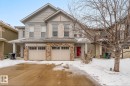 The property features an attached garage with two garage doors and stone accents on the facade - 3109 Carpenter Landing, Edmonton, AB  - Outdoor With Facade 