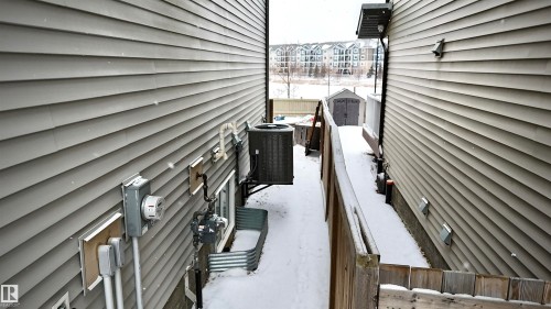 The property features exterior siding, a ground-level window with a window well, and an outdoor HVAC unit - 3109 Carpenter Landing, Edmonton, AB - Outdoor