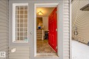 Inviting entryway featuring a vibrant red door, tiled flooring, and a stairway with white railings - 3109 Carpenter Landing, Edmonton, AB  - Outdoor With Exterior 