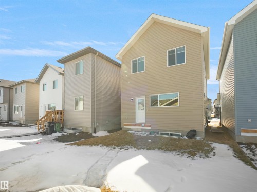 The property features a two-story exterior with light beige siding and a white trim - 1304 14 Avenue, Edmonton, AB - Outdoor With Exterior