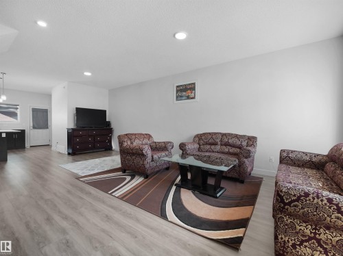 This open concept living area features light-toned flooring, recessed lighting, and a neutral wall color - 1304 14 Avenue, Edmonton, AB - Indoor