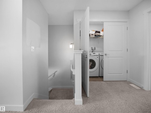 A dedicated laundry area features a washer and dryer, along with shelving for storage - 1304 14 Avenue, Edmonton, AB - Indoor Photo Showing Laundry Room