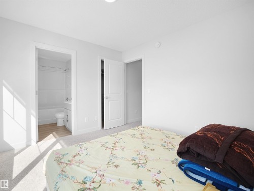 This room features light-colored carpet, a ceiling light fixture, and white walls - 1304 14 Avenue, Edmonton, AB - Indoor Photo Showing Bedroom