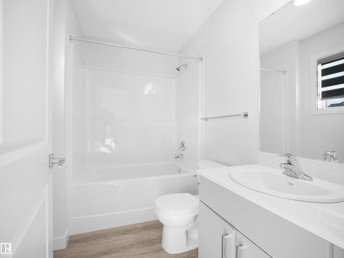 Bathroom featuring a bathtub with an overhead shower, a toilet, and a vanity with an integrated sink - 1304 14 Avenue, Edmonton, AB - Indoor Photo Showing Bathroom