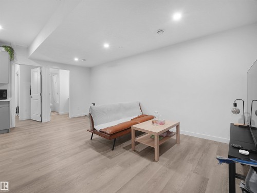 This open concept space features light-toned flooring, white walls, and recessed lighting throughout - 1304 14 Avenue, Edmonton, AB - Indoor