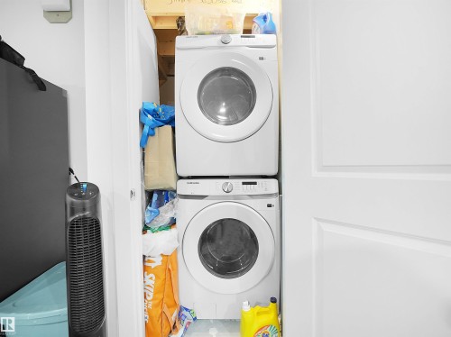 Dedicated laundry area featuring a white stacked washer and dryer unit - 1304 14 Avenue, Edmonton, AB - Indoor Photo Showing Laundry Room