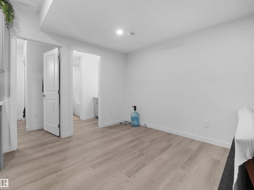 This room features light-colored plank flooring and white walls, creating a bright and airy atmosphere - 1304 14 Avenue, Edmonton, AB - Indoor Photo Showing Other Room