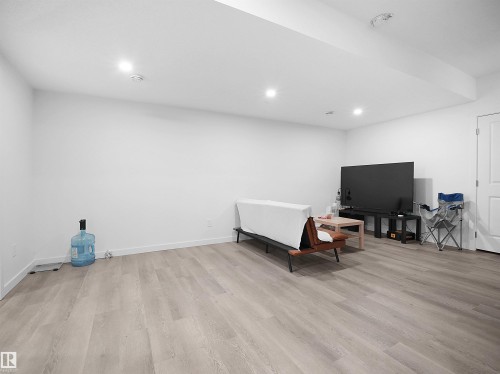 This bright room features light-colored flooring, recessed lighting, and a white door - 1304 14 Avenue, Edmonton, AB - Indoor