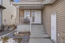 The property features a front porch with white railings, a white entry door, and a stone-clad column - 6014 60 Street, Beaumont, AB  - Outdoor With Deck Patio Veranda With Exterior 