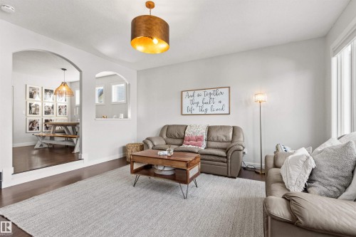 Living area with hardwood flooring, a ceiling-mounted light fixture, and an arched entry - 38 Hewitt Circle, Spruce Grove, AB - Indoor Photo Showing Living Room
