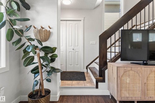 Entryway featuring hardwood flooring, a white paneled door, and a staircase with dark wood handrails and black balusters - 38 Hewitt Circle, Spruce Grove, AB - Indoor Photo Showing Other Room