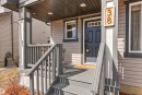 Welcoming front porch with gray steps and railings, featuring a dark paneled door with transom windows - 38 Hewitt Circle, Spruce Grove, AB  - Outdoor With Deck Patio Veranda With Exterior 