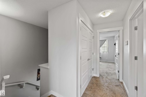 Bright hallway with white doors, light-colored walls, and a recessed ceiling light fixture - 2725 Orchards Road, Edmonton, AB - Indoor Photo Showing Other Room