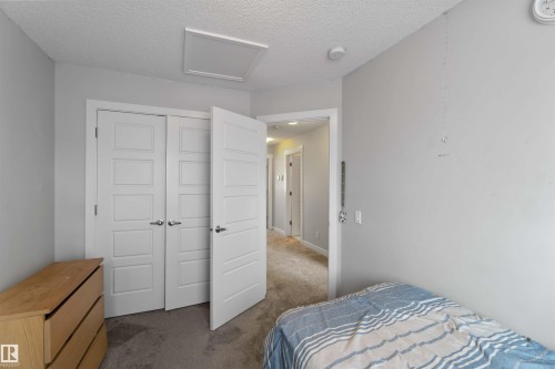 This room features light grey walls and grey carpet flooring - 2725 Orchards Road, Edmonton, AB - Indoor Photo Showing Bedroom