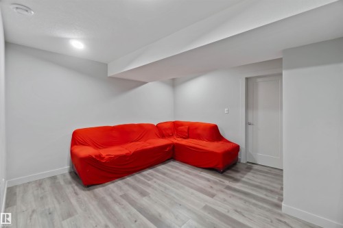 Spacious room with light gray walls, recessed lighting, and wood-look flooring - 2725 Orchards Road, Edmonton, AB - Indoor Photo Showing Other Room