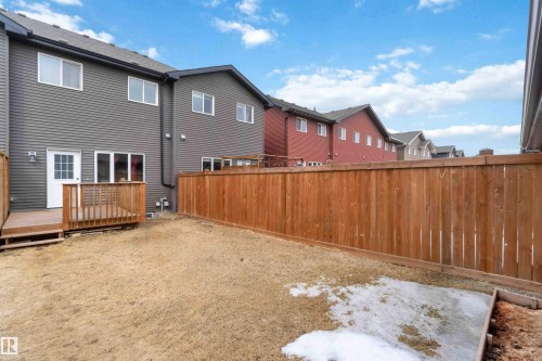 The property features a fenced yard with a wooden deck and a back entrance - 2725 Orchards Road, Edmonton, AB - Outdoor With Exterior