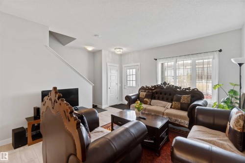 The living area features light-colored walls and flooring, with a window providing natural light - 2725 Orchards Road, Edmonton, AB - Indoor Photo Showing Living Room