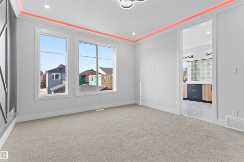 Spacious room featuring carpeting, large windows, and decorative ceiling lighting - 156 Wyatt Ridge, Fort Saskatchewan, AB - Indoor Photo Showing Other Room
