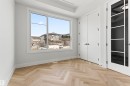 This room features light-colored herringbone pattern flooring, a large window providing natural light, and a white paneled door with dark hardware - 156 Wyatt Ridge, Fort Saskatchewan, AB  - Indoor Photo Showing Other Room 