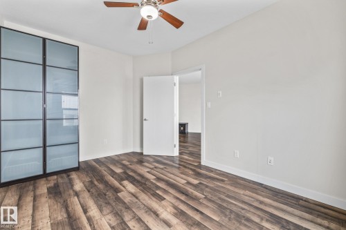 The property features wood-look flooring and a ceiling fan - 212 10611 117 Street, Edmonton, AB - Indoor Photo Showing Other Room