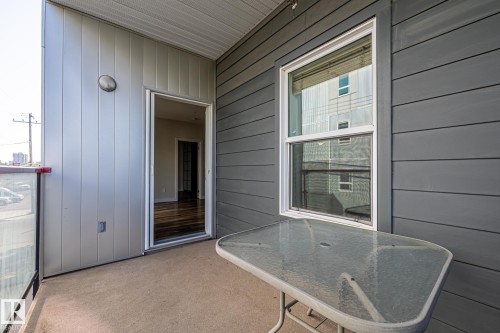 The property features a private balcony with a glass railing and a light-colored concrete floor - 212 10611 117 Street, Edmonton, AB - Outdoor With Exterior