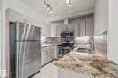 The kitchen features stainless steel appliances, granite countertops, and light-colored cabinetry - 212 10611 117 Street, Edmonton, AB  - Indoor Photo Showing Kitchen With Double Sink With Upgraded Kitchen 